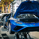 A photo of a blue Lamborghini supercar being assembled at a factory.